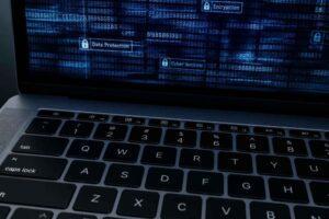Laptop z ekranem przedstawiającym szyfrowanie, ochronę danych i cyberbezpieczeństwo