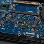 Zbliżenie płyty głównej laptopa z układem BIOS, gniazdem DIMM-B i wentylatorem.