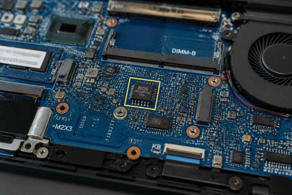 Zbliżenie płyty głównej laptopa z układem BIOS, gniazdem DIMM-B i wentylatorem.